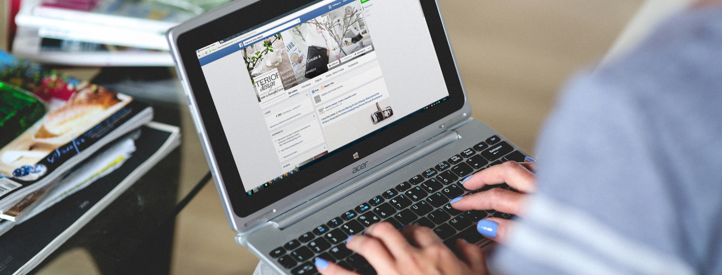 Frau mit laptop auf den knien ist bei facebook auf jobsuche