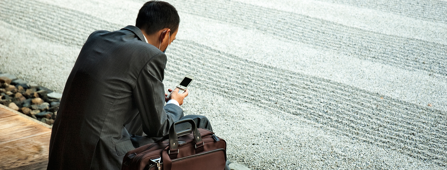 R ckansicht von sitzendem mann im anzug mit telefon in der hand telefoninterview