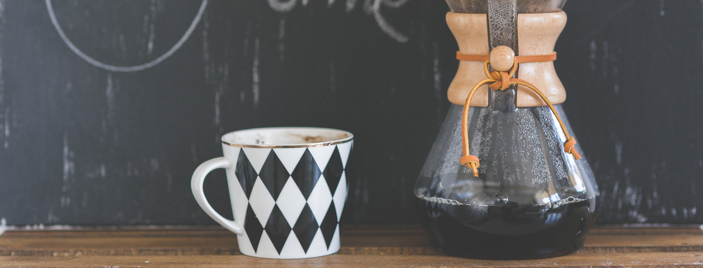 Kaffee kanne und tasse auf holz vor kreidetafel