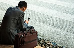 Small r ckansicht von sitzendem mann im anzug mit telefon in der hand telefoninterview