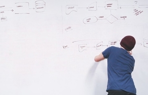 Small r ckansicht von jungem mann mit m tze der plan am whiteboard macht fragen vor dem praktikum